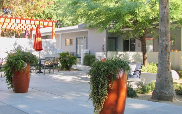 Outdoor seating area with planters and shaded umbrella.