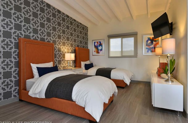 A stylish bedroom with two beds and modern decor.