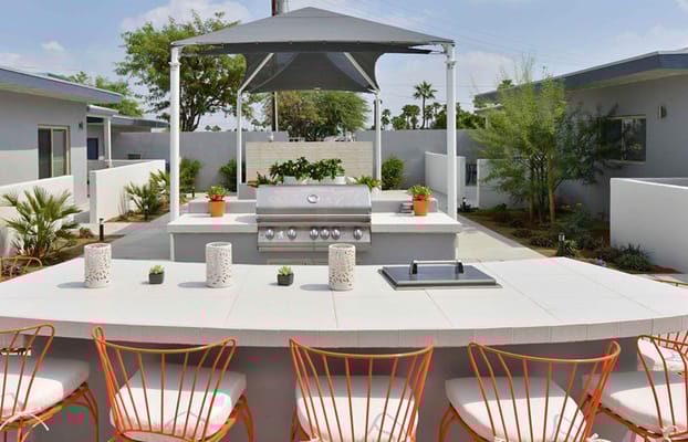 Outdoor kitchen with grill and seating at Stonewall Gardens Assisted Living