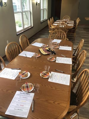 Dining table set for a wine tasting event with menus and snacks