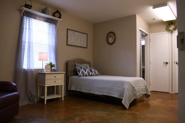 Comfortable bedroom with a bed, nightstand, and decorative elements.