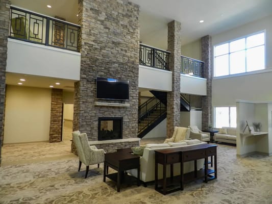 Spacious living room with stone accents and seating areas.