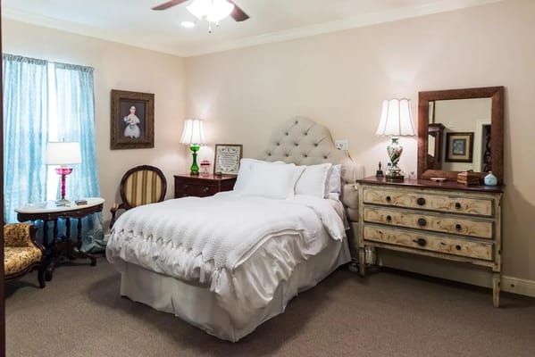 Comfortable bedroom with a bed, dresser, and decorative lamp