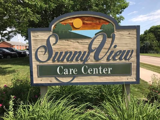Sign for Sunny View Care Center with green grass and blue sky