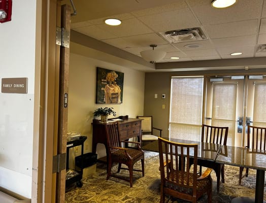 Cozy family dining area with a wooden table and chairs at Sunny View Care Center.