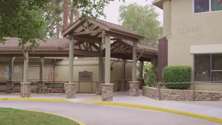 Main entrance with covered walkway and stone pillars