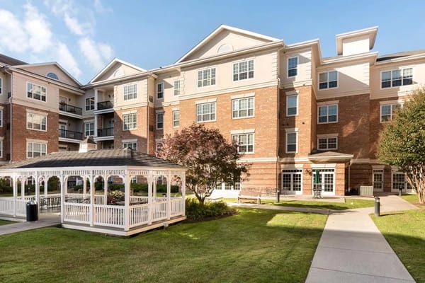 Exterior view of senior living facility with gazebo and lawn