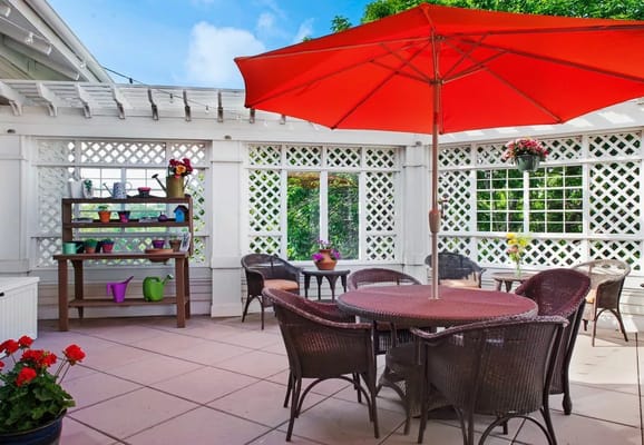 Outdoor patio with seating and a bright umbrella