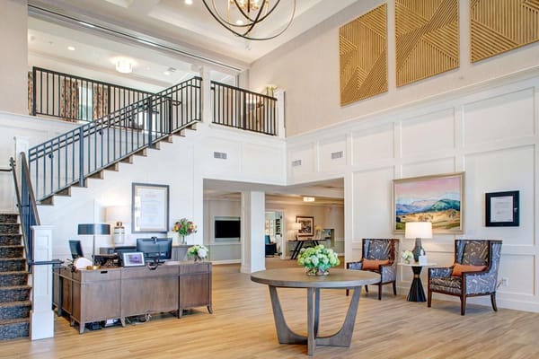Bright and spacious lobby with a reception desk, seating area, and decorative art