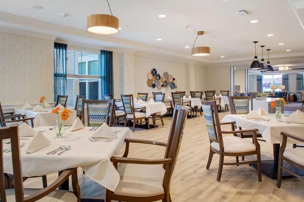 Bright and inviting dining room with tables set for meals
