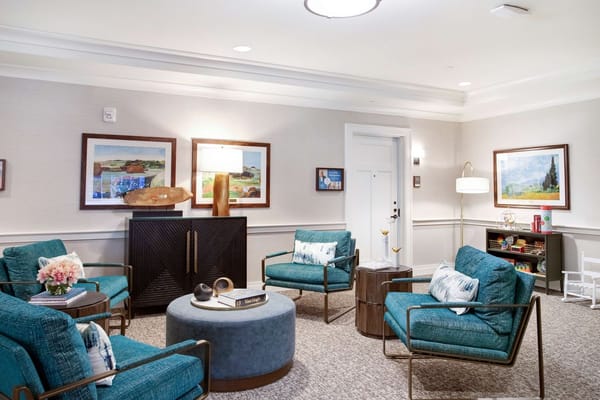 Lounge with teal chairs and artwork on the walls