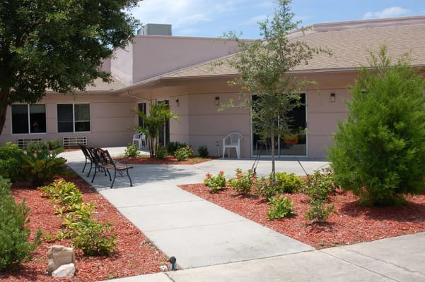 Pathway with benches and landscaped garden at Surrey Place Healthcare