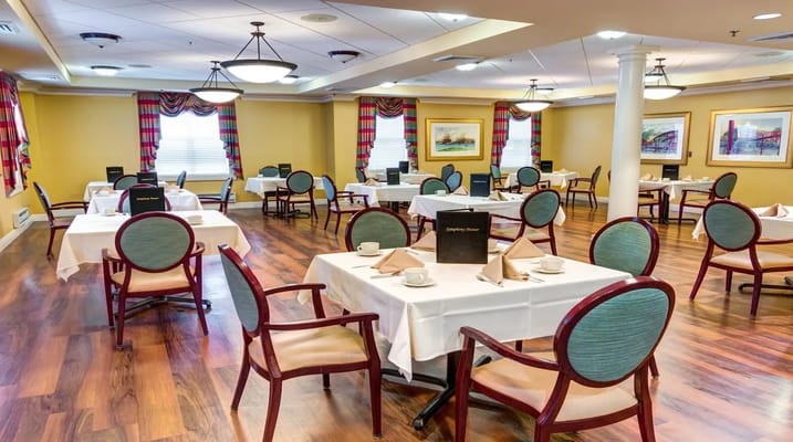 Dining area with tables set for meals at Symphony Manor.