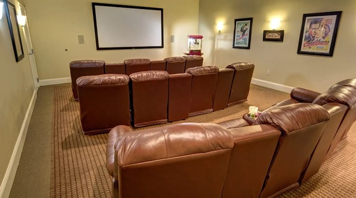 Seating area in a theater room with a large screen and popcorn machine