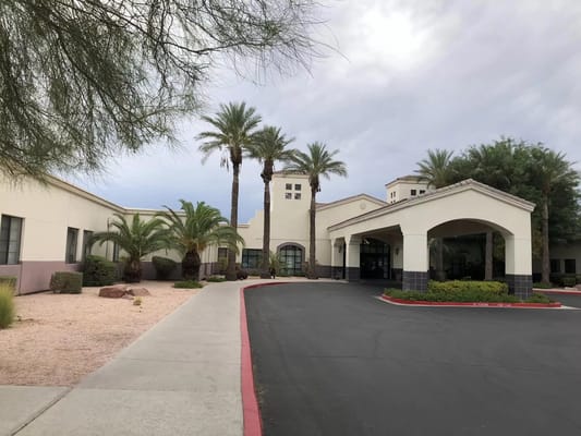 Exterior view of TLC Care Center with palm trees