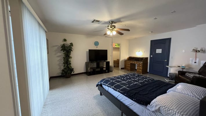 Cozy bedroom with a bed, TV, and desk at Tender Loving Memory Care