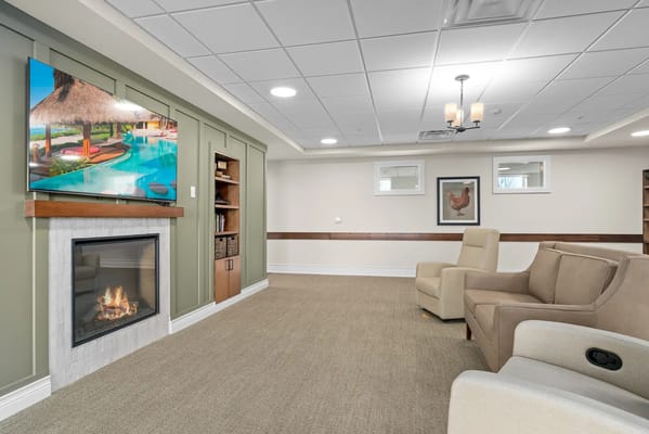 Living room with fireplace and TV displaying a pool scene