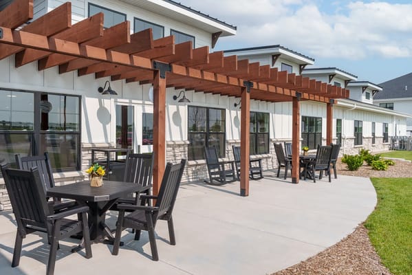 Outdoor seating area with tables and chairs under a pergola