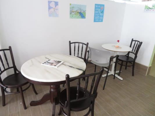 A cozy dining area with marble and wooden tables and chairs.