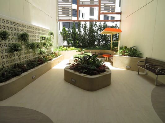 A bright and green garden space with seating in Tampines Care Home.