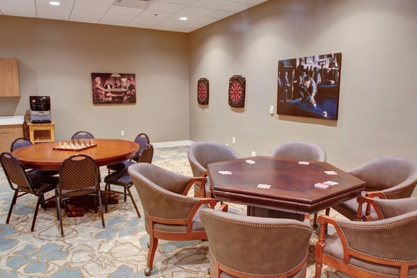 Cozy game room with a round table, card games, and dartboards