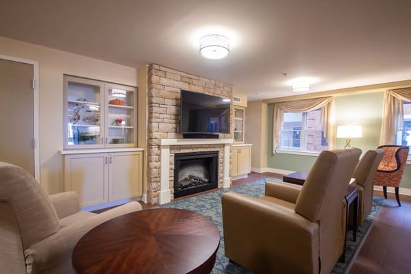 A comfortable living room with a stone fireplace and seating area.