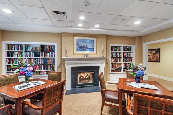 Inviting living room with bookshelves and floral centerpiece.