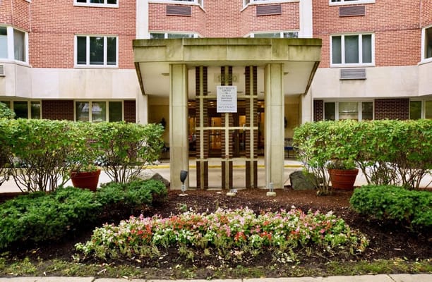 Front entrance of Ten Twenty Grove senior living facility, with landscaped garden