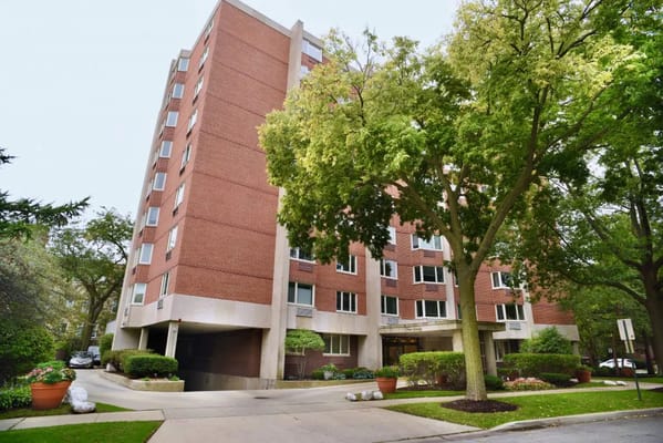 Exterior of Ten Twenty Grove senior living facility surrounded by greenery.
