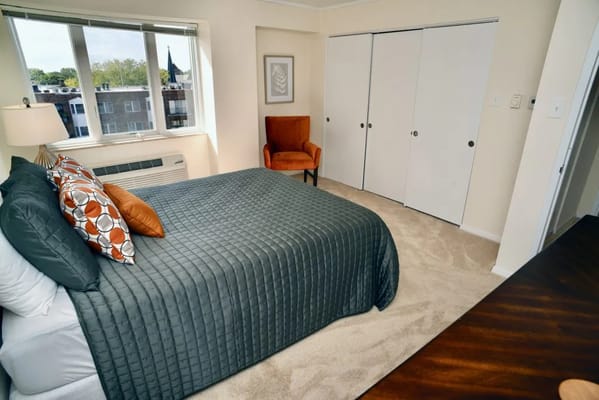 Bright and inviting bedroom with a large bed and a comfortable chair.