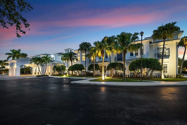 Exterior view of Tequesta Terrace with palm trees at dusk