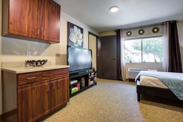 Comfortable bedroom featuring wooden furniture and a TV.