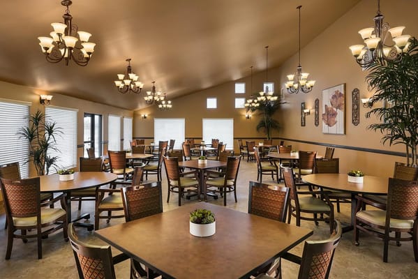 Well-lit dining room with tables and chairs at Terra Pointe Memory Care.