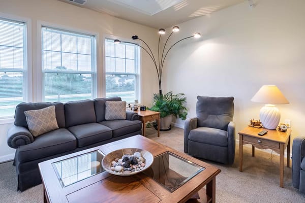 Living room with a comfortable couch and lamp.