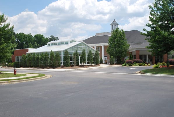 Main entrance of The Arboretum at Woodland Terrace with greenhouse and landscaping