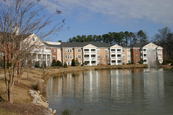 Scenic view of the buildings by the lake with a fountain at The Arboretum at Woodland Terrace.