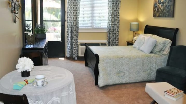 Cozy bedroom featuring a bed, seating area, and decorative elements.