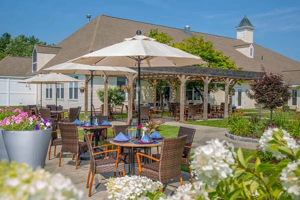 Patio dining setup under umbrellas at The Arbors of Shelburne