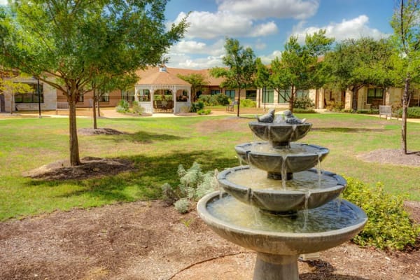 Outdoor garden with a fountain and building facade
