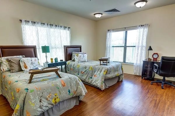 Brightly lit double resident room with beds and decor