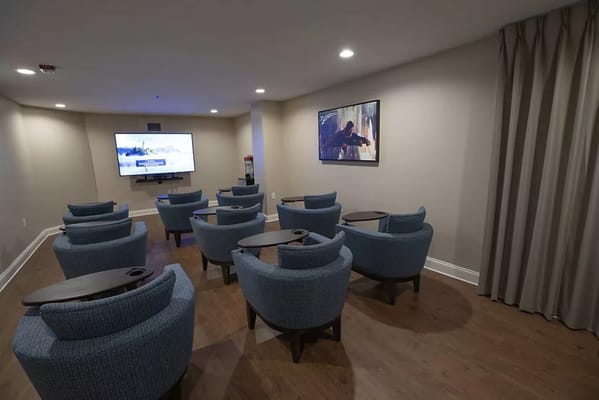 Cozy media room with blue chairs and a television.