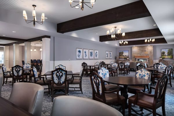 Spacious dining room with elegant wooden chairs and floral-patterned upholstery.