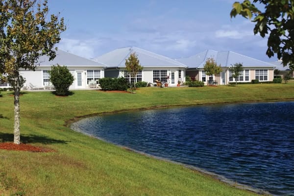 Exterior view of assisted living facility by a pond