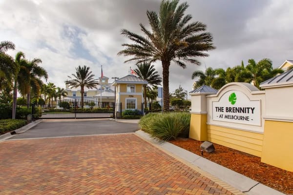 Entrance view of The Brennity at Melbourne with palm trees