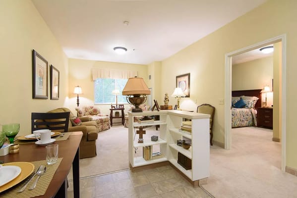 Living area featuring a sofa, dining table, and access to a bedroom.