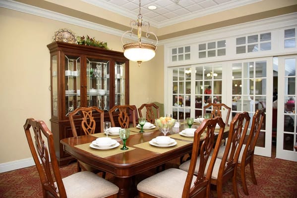 Elegant dining room with a large wooden table set for a meal.