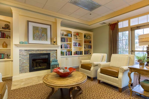 Lounge area featuring comfortable chairs, a coffee table, and bookshelves