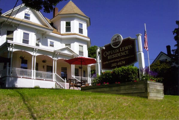 Exterior view of The Captain Lewis Residence with sign and outdoor seating