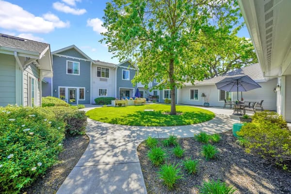 Beautiful courtyard with green grass and shaded seating area