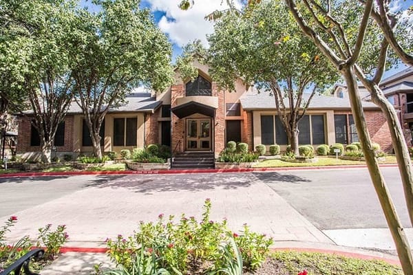 Exterior view of The Continental Retirement Community building surrounded by trees.